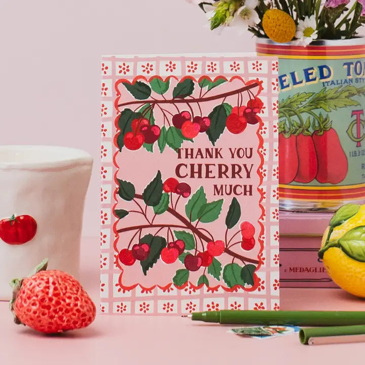 Card with cherry design and 'Thank you cherry much' text on a pink background with decorative items.