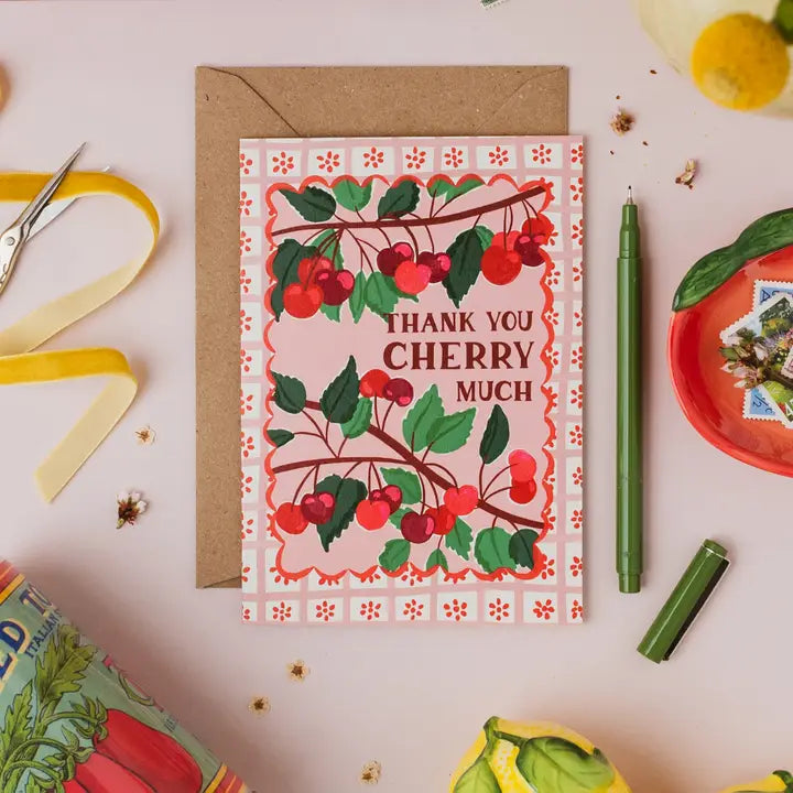Greeting card with cherry design and 'Thank you cherry much' text on a decorative surface.