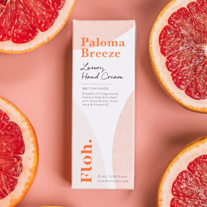 Paloma Breeze hand cream box surrounded by grapefruit slices on a pink background