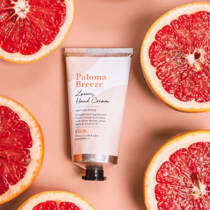 Paloma Breeze hand cream with sliced grapefruits on a pink background
