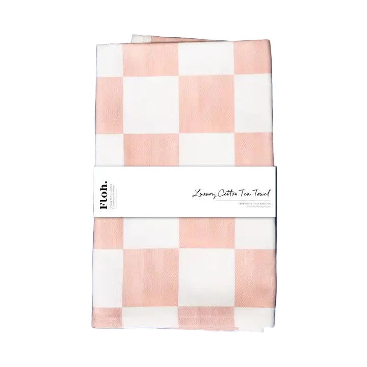 Checkered pink and white tea towel with a label on a purple background