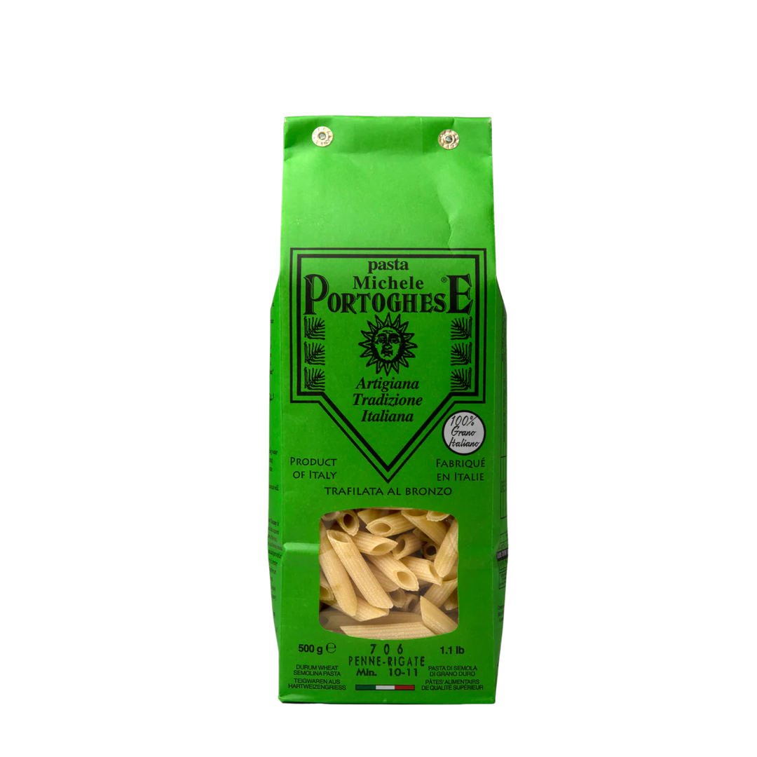 Green package of Michele Portoghesi penne pasta on a white background
