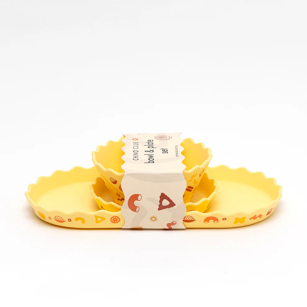 Set of yellow silicone bowls with a packaging label on a white background