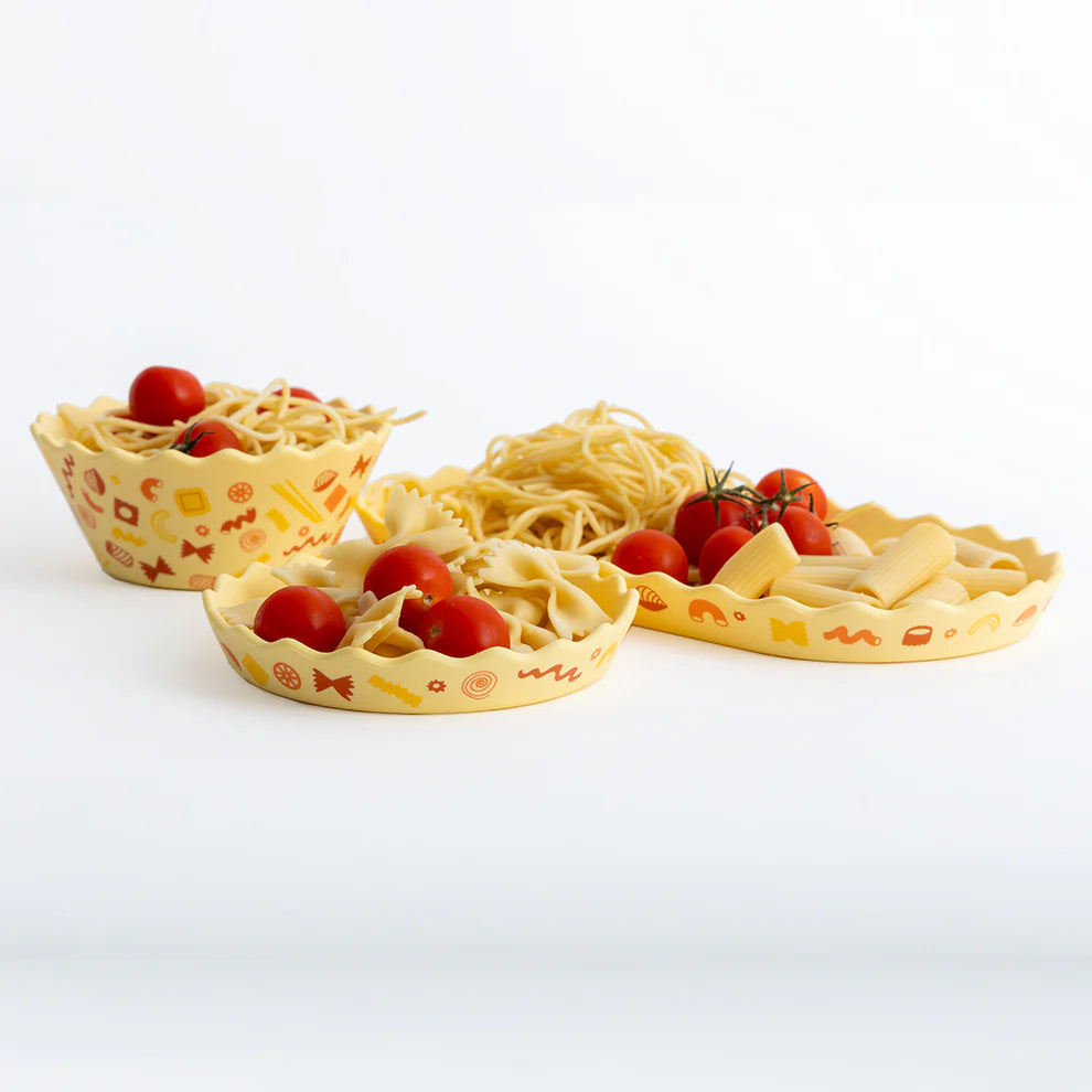 Three decorative pasta dishes with spaghetti and tomatoes on a white background