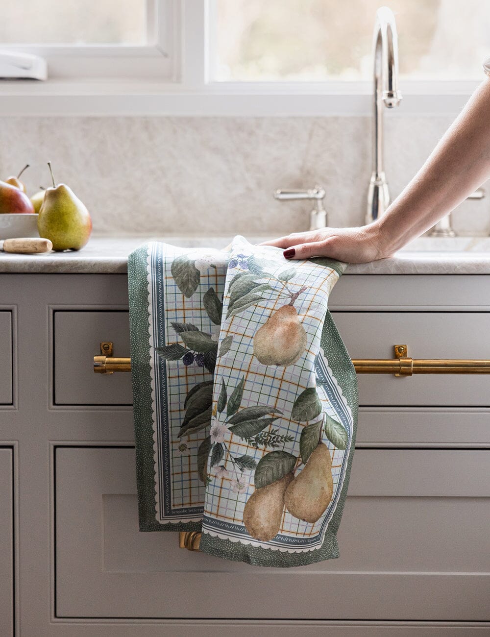 Kitchen towel with pear design hanging on a cabinet handle