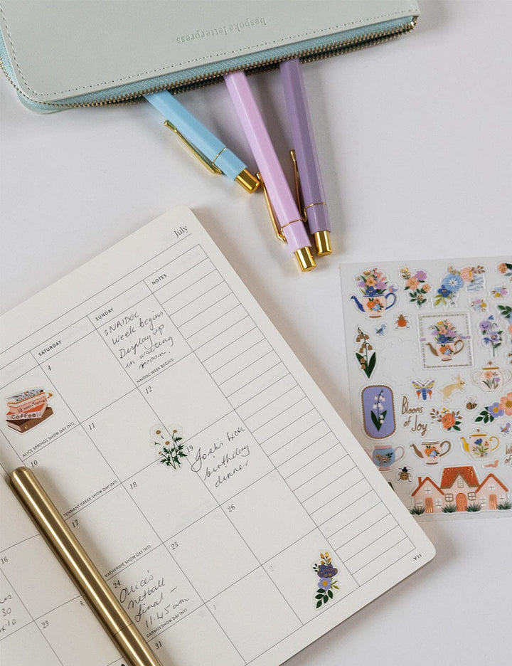 Planner with stickers and pens on a light surface