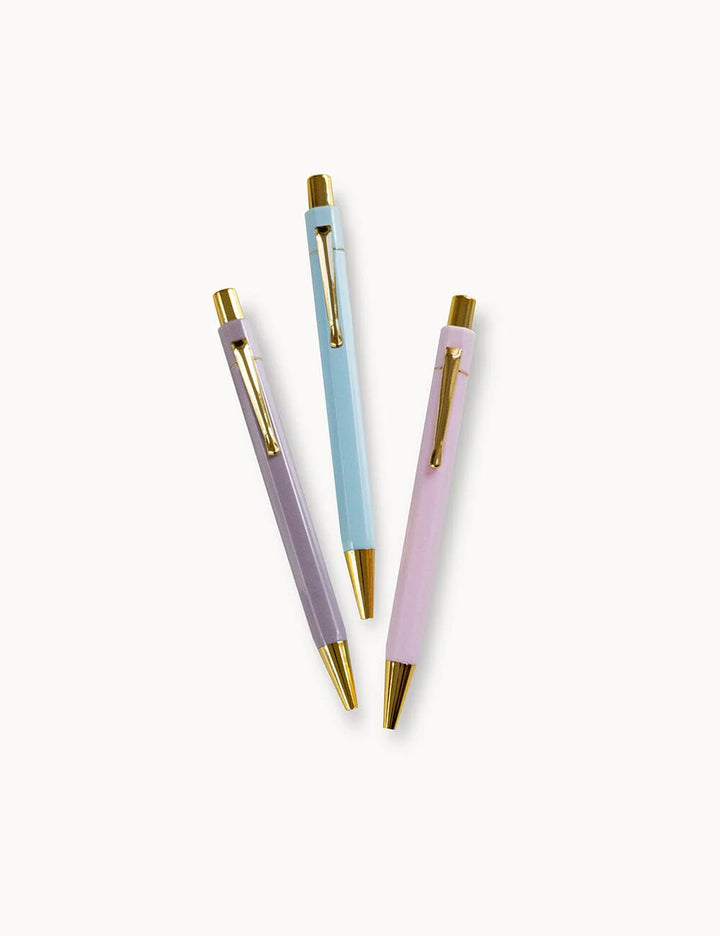 Three pens with pastel-colored bodies and gold accents on a white background