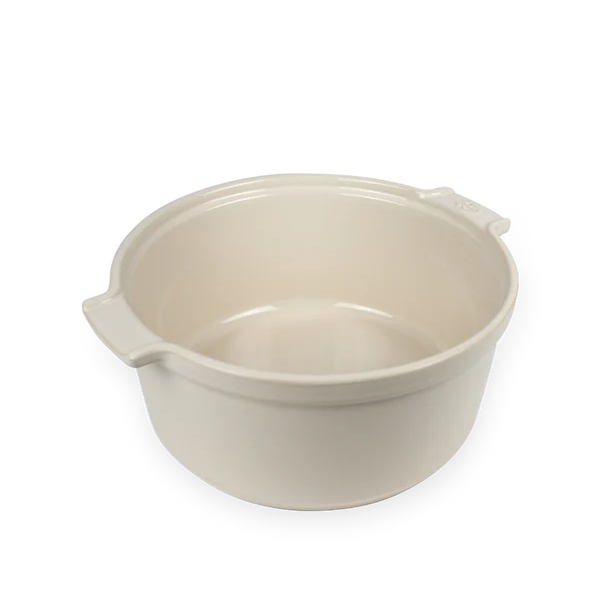 Beige ceramic souffle dish with handles on a white background