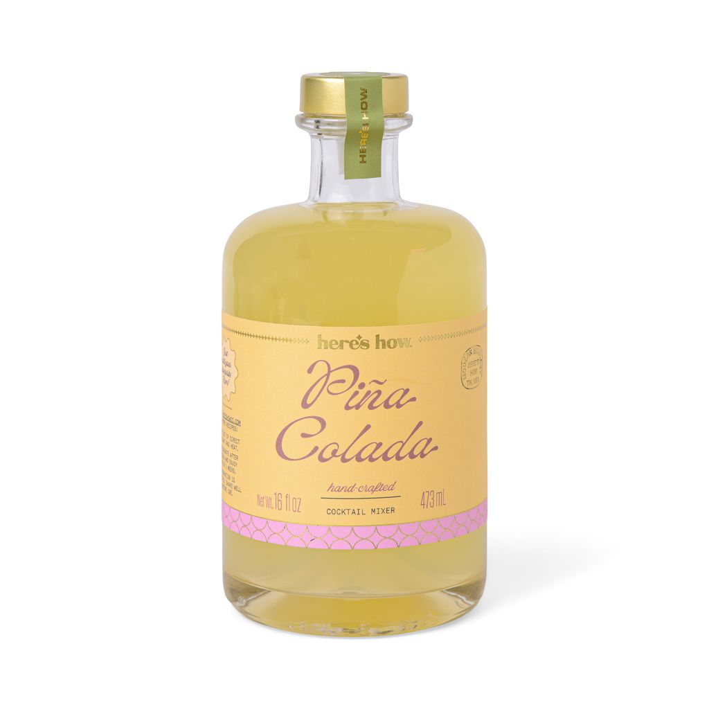 Bottle of Pina Colada mixer with a gold cap on a white background