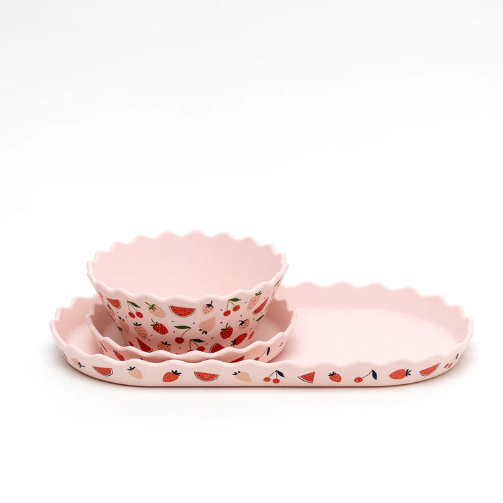 Set of pink silicone dishes with strawberry pattern on a white background