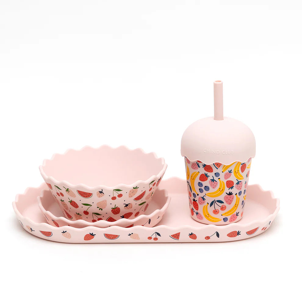 Children's tableware set with pink bowls and cup on a white background