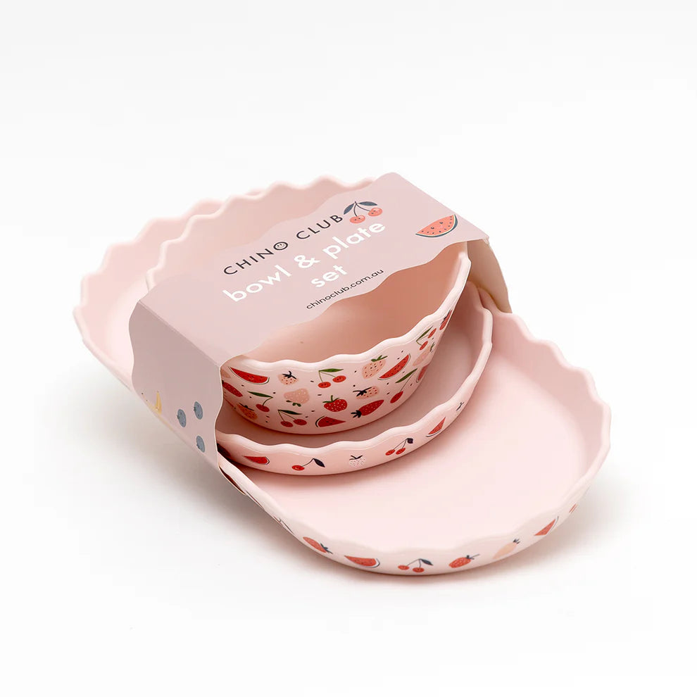 Pink bowl and plate set with fruit patterns in a box on a white background