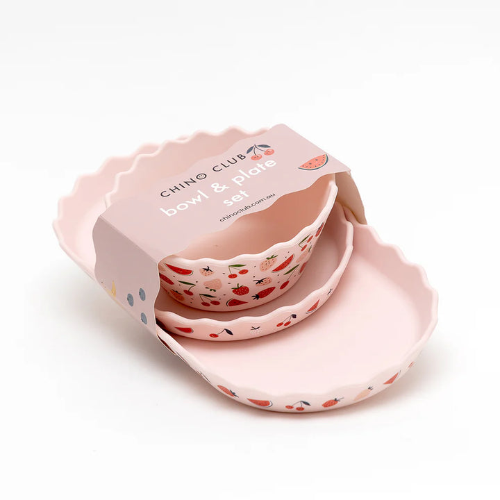 Pink bowl and plate set with fruit patterns in a box on a white background