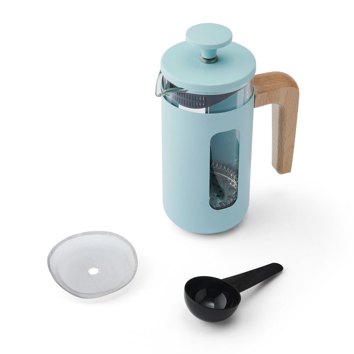 Blue French press coffee maker with wooden handle and accessories on a white background