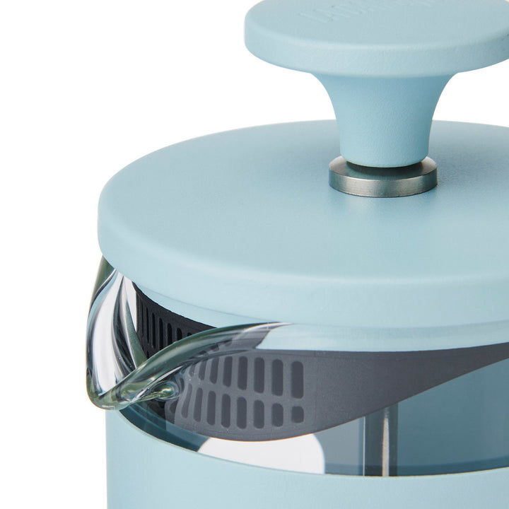 Close-up of a light blue kitchen appliance with a metallic handle on a white background