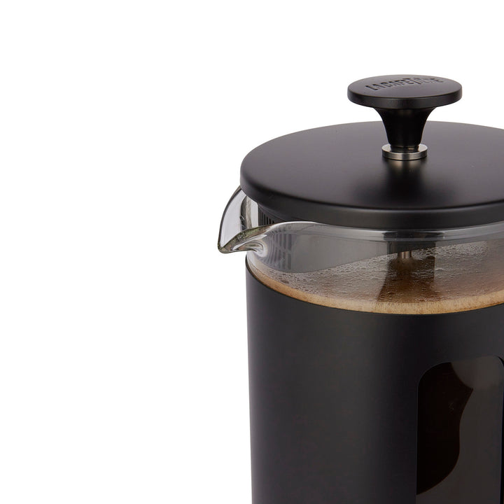 Black French press coffee maker with a clear glass container on a white background