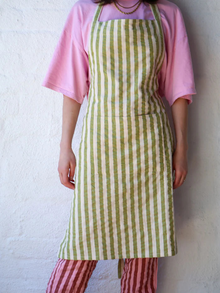 person wearing a green and white stripe apron
