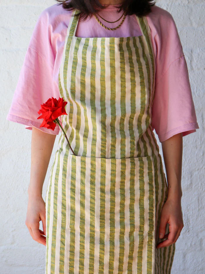 Person wearing a green and white stripe apron