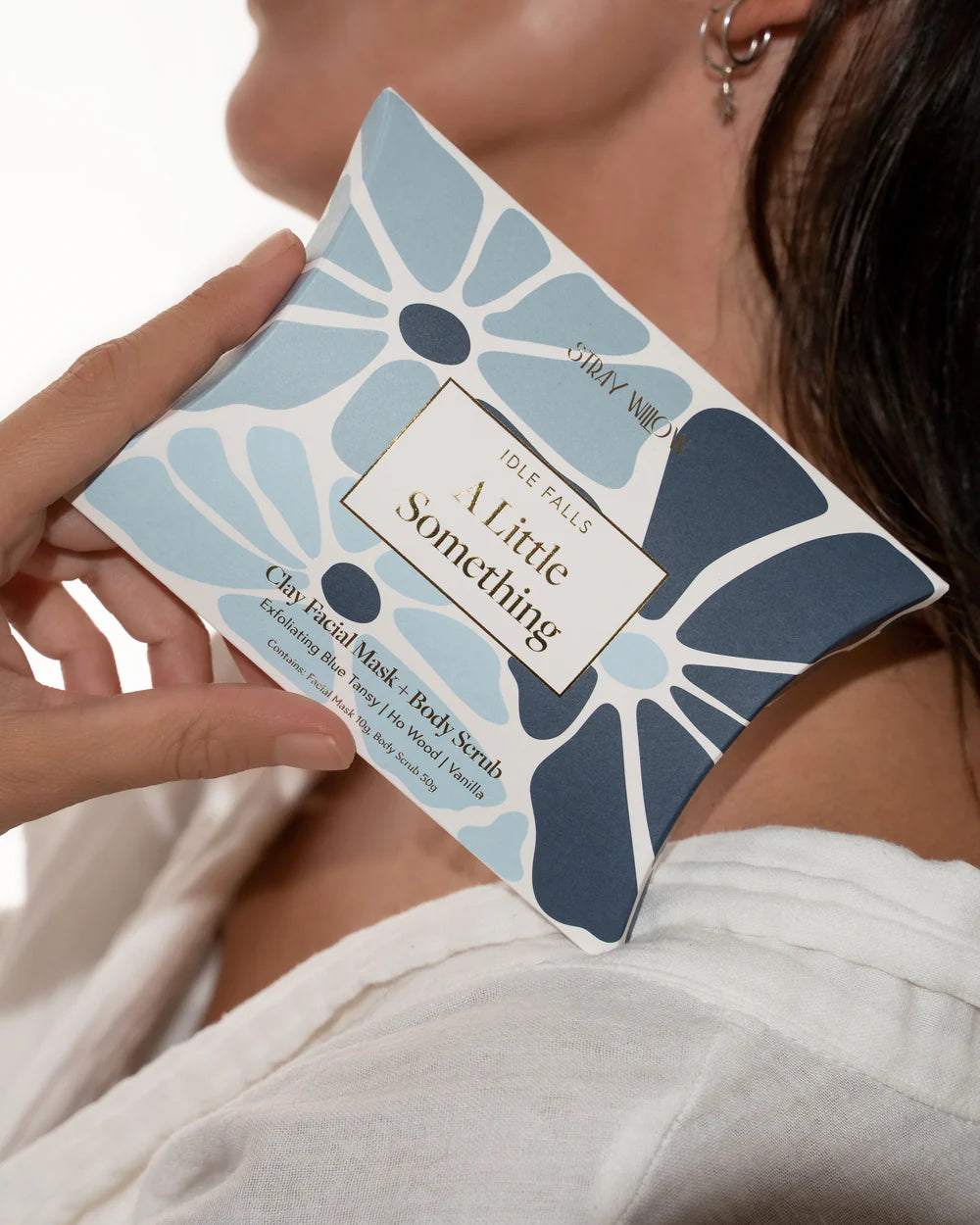 Person holding a product packaging with floral design and text