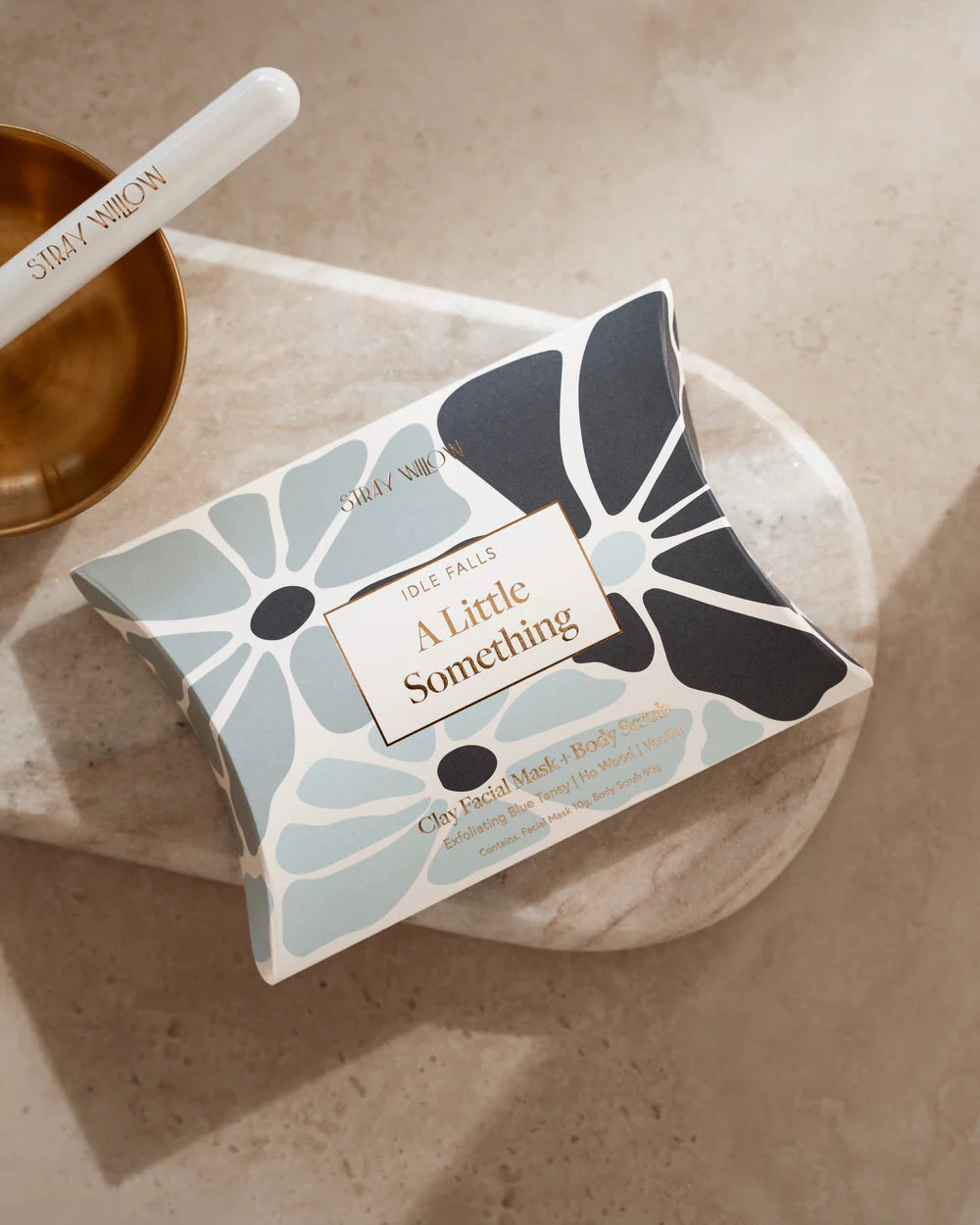 Face mask packaged in a floral designed box and 'A Little Something' text on a neutral background