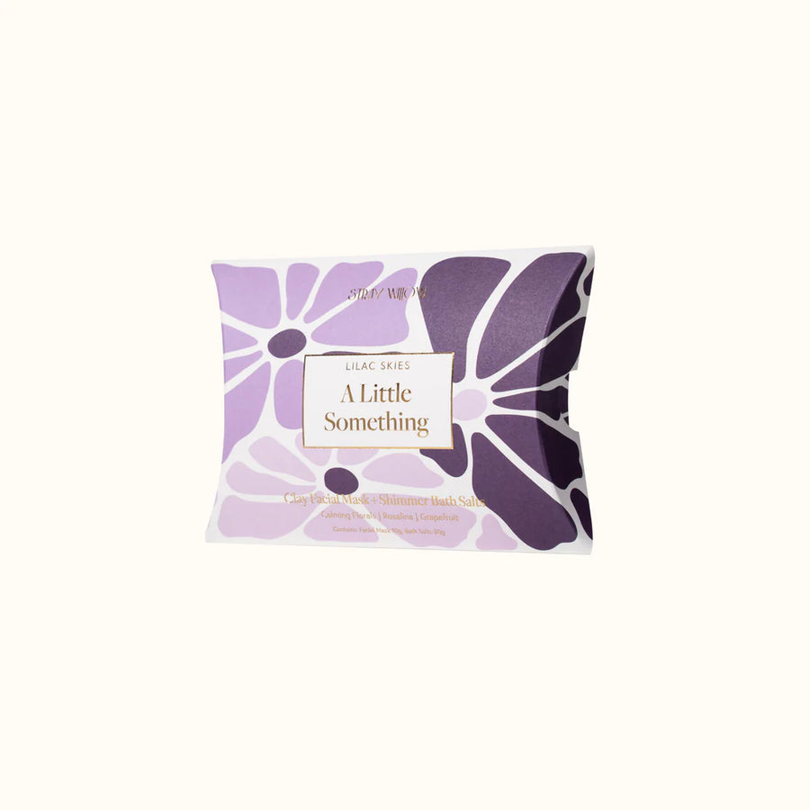 Purple floral face mask packaging with 'A Little Something' text on a white background