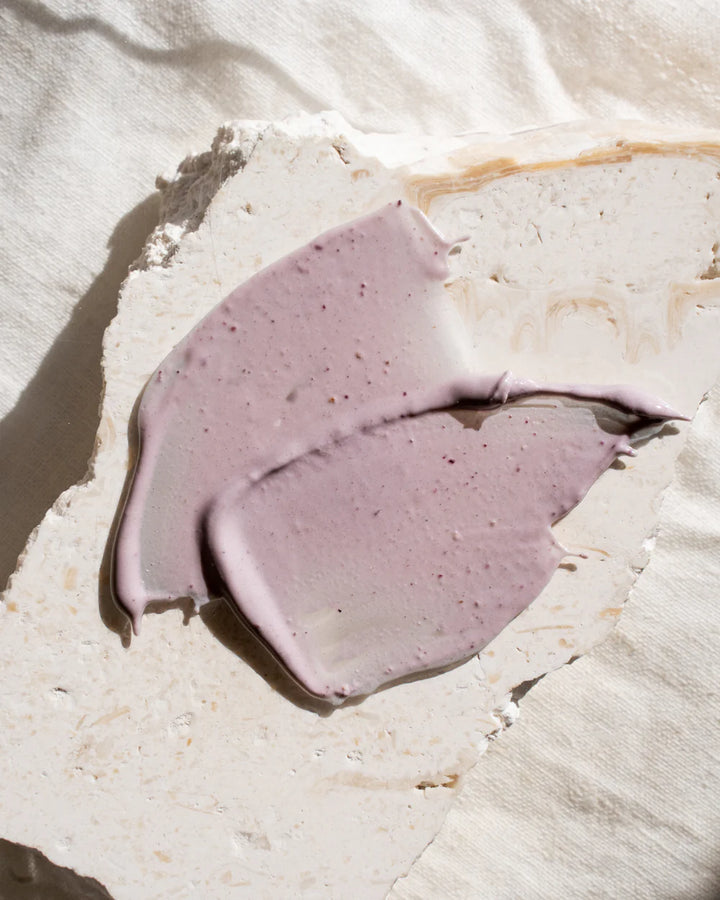 Purple face mask smear on a light stone surface