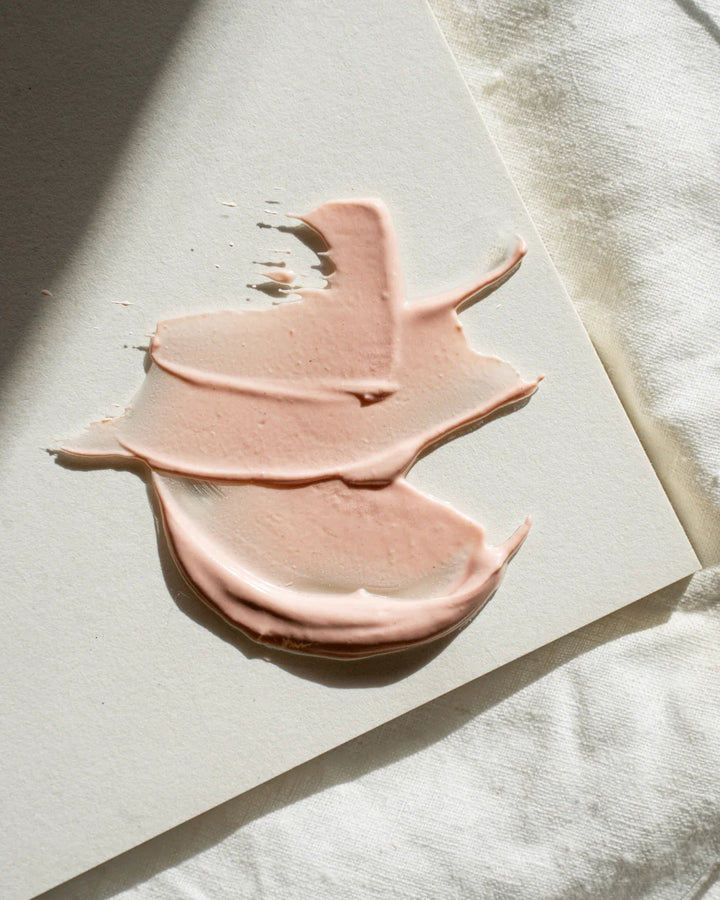Pink face mask product swatch on a light surface