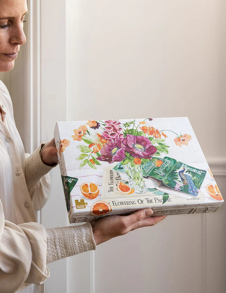 Woman holding a puzzle box with floral design and text