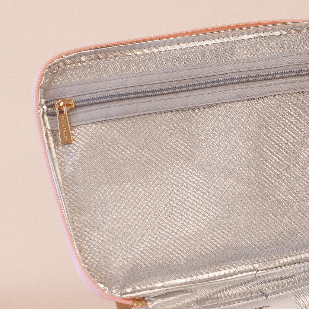 Inside of an insulated lunch bag with a zipper on a beige background