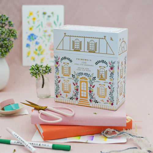 Decorative stationery set with Primrosia branding on a pink surface