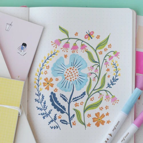 Colorful floral illustration on a notebook page with markers around.