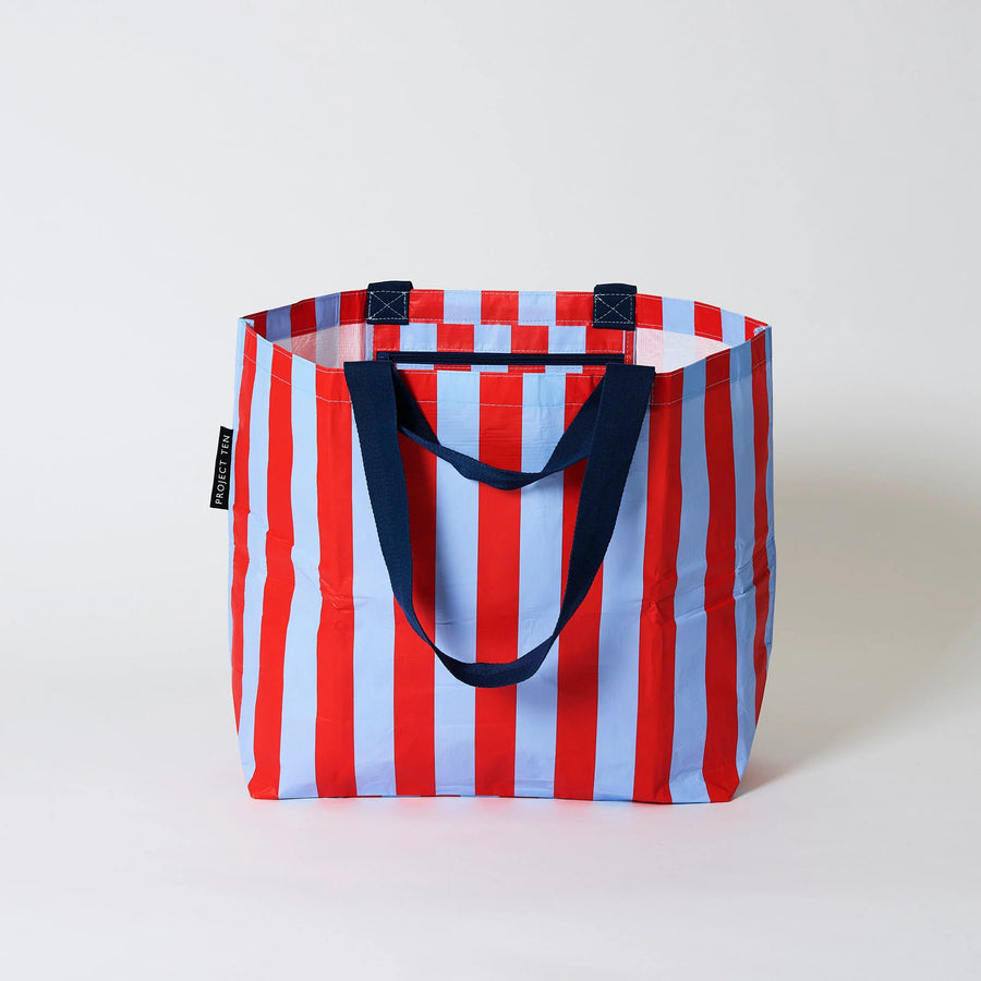 Red and blue striped tote bag with navy blue handles on a white background