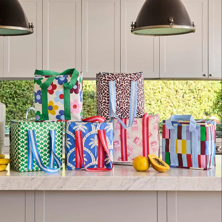 Colorful patterned bags on a kitchen counter with a blurred outdoor background