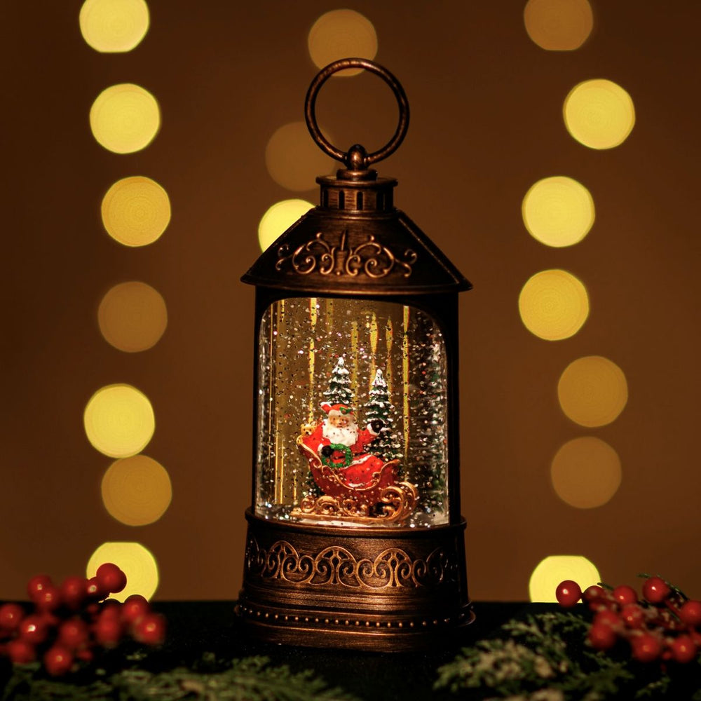 Decorative lantern with Santa Claus figure inside, surrounded by festive decorations and blurred lights in the background.