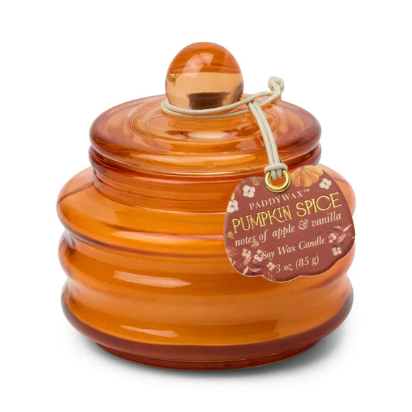 Orange candle jar with a label on a white background