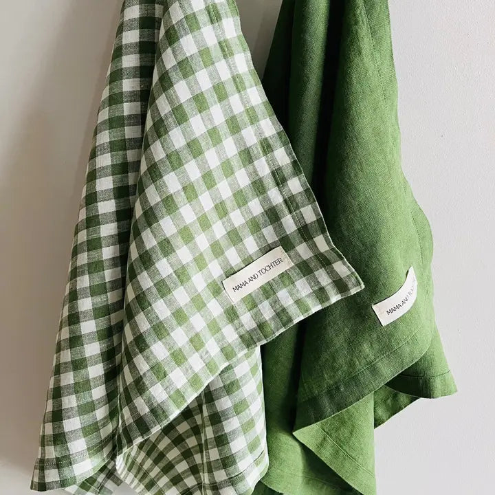 Green checkered towel and solid green towel with 'Mama and Tochter' label on a light gray background