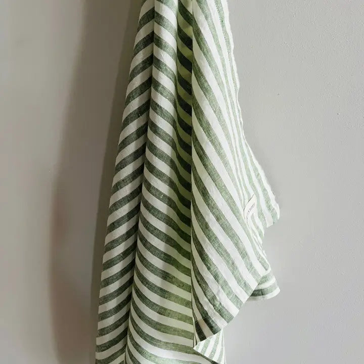 Green and white striped tea towel on a gray background