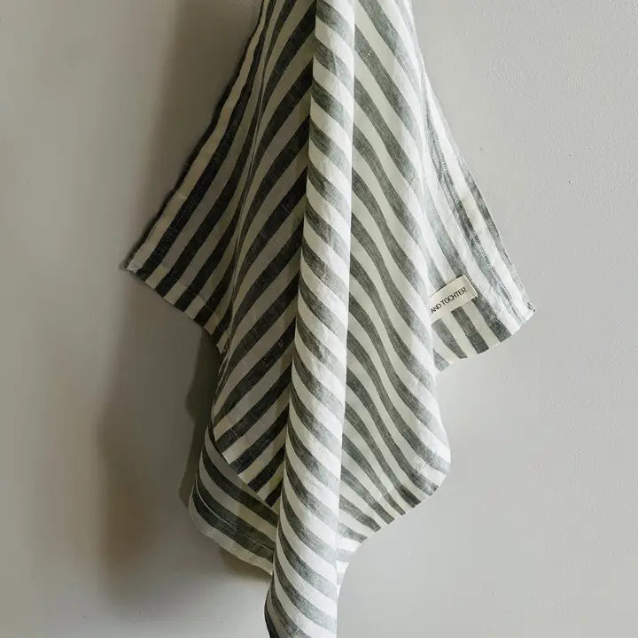 Striped towel with a brand label on a plain background