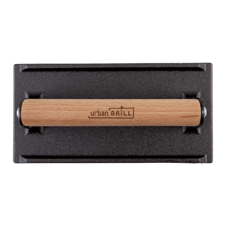 Black cast iron grill press with wooden handle on a white background