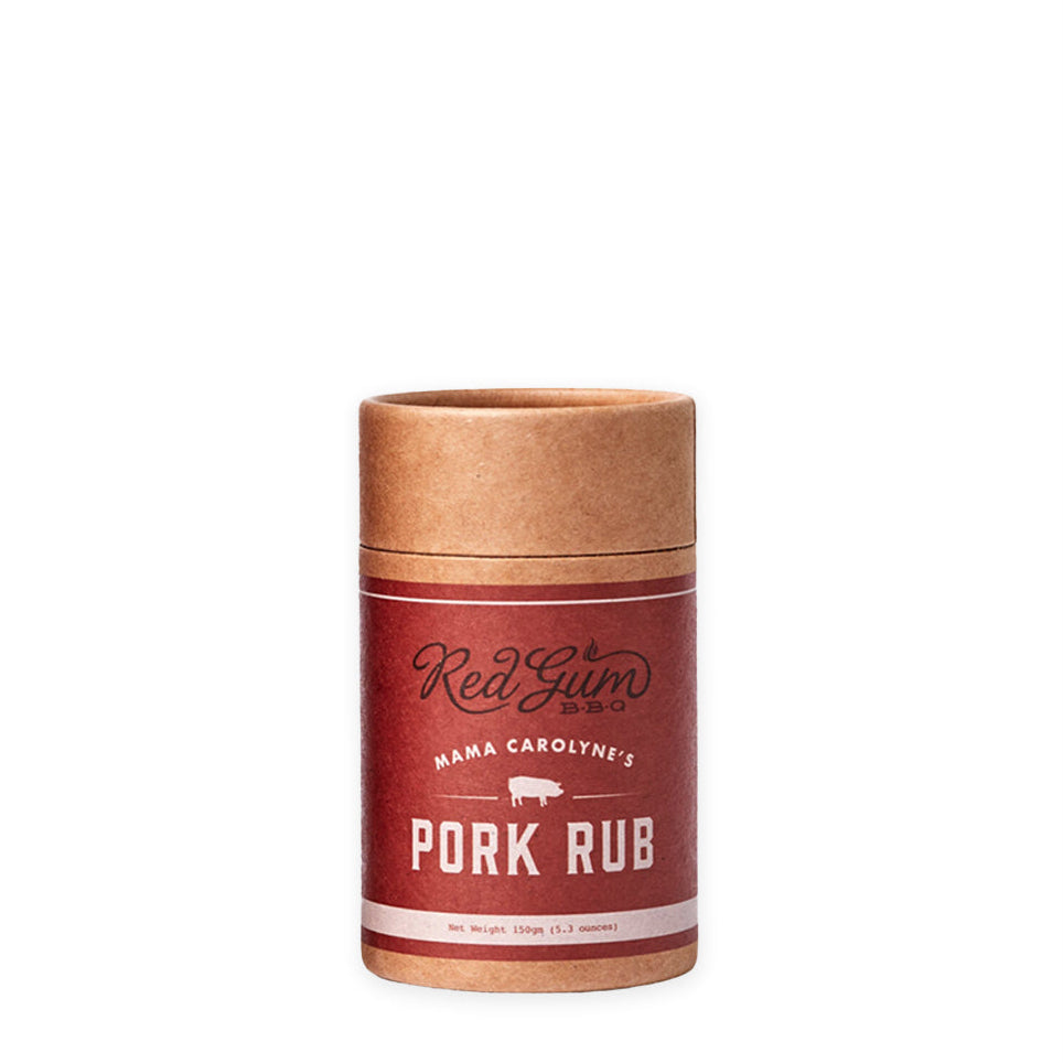 A cylindrical container of Red Gum BBQ Mama Carolyne's Pork Rub with a red label and brown lid.