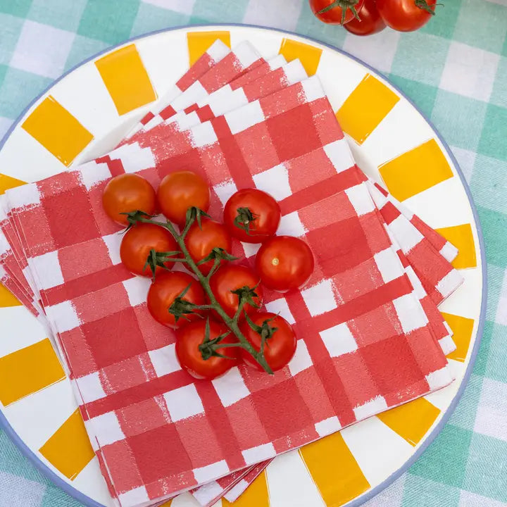 Red checkered napkins on a plate with cherry tomatoes on a checkered tablecloth