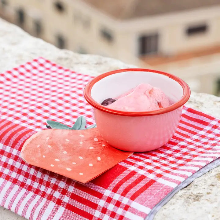 Pink bowl with ice cream on a red and white checkered tablecloth