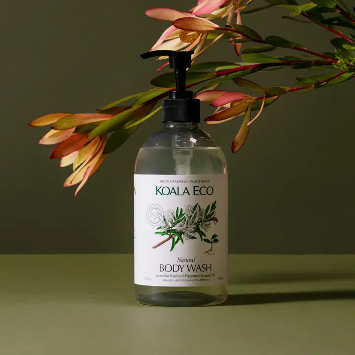 Koala Eco natural body wash on a green background with florals