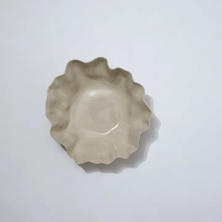 Beige ceramic pie dish with scalloped edge on a white background