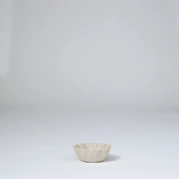 Small beige ceramic bowl on a light gray background