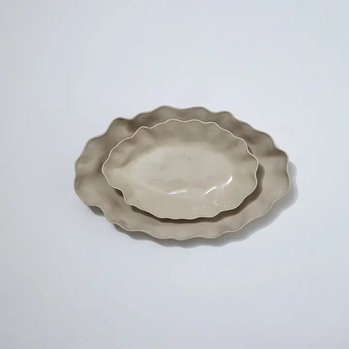 Two ceramic plates with scalloped edges on a white background