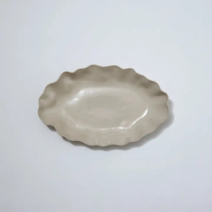 Decorative ceramic plate with scalloped edge on a white background