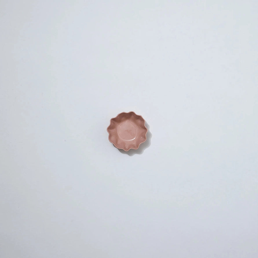 Small pink ceramic dish on a light gray background