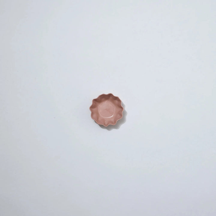 Small pink ceramic dish on a light gray background