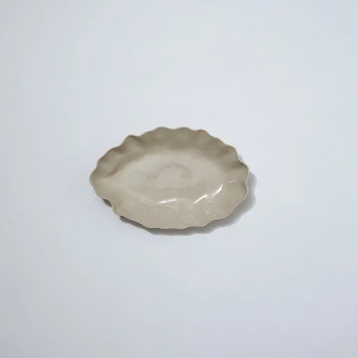 Ceramic dish with scalloped edge on a white background